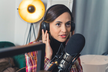 radio host woman talking into a microphone and broadcasting at the radio station, entertainment concept medium closeup job concept. High quality photo