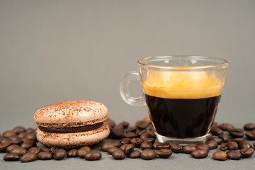 close up of coffee mug scattered coffee beans and  macarons cookies