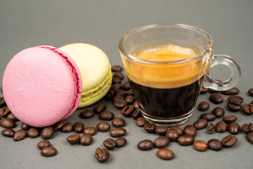close up of coffee mug scattered coffee beans and  macarons cookies