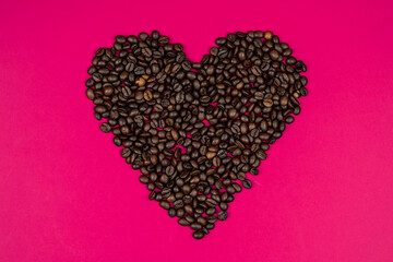 heart  of coffee beans on a pink background
