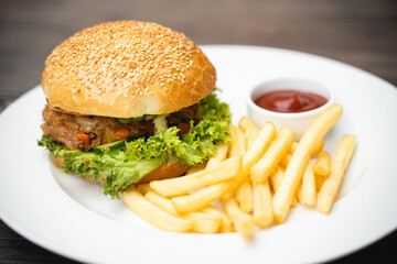 menu with delicious juicy burger and fries with sauce on a plate.
