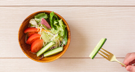 A girl eating salad. サラダを食べる女の子