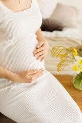 Image of pregnant woman touching her belly with hands