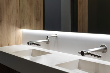Bathroom with two sinks, big mirror, wooden walls and ambient lights 