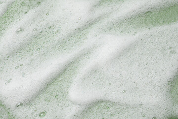 White washing foam on olive background, top view