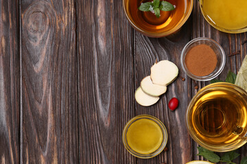 Flat lay composition of tea with honey and ingredients on wooden table. Space for text