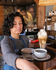Waitress carrying tray of coffee and frappe