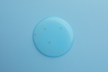 Sample of face gel on light blue background, top view