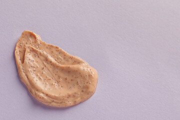 Sample of scrub on lilac background, top view. Space for text