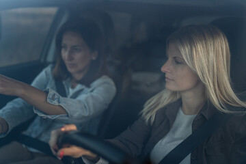 Fototapeta na wymiar two women drive in a car travel mature caucasian female friends