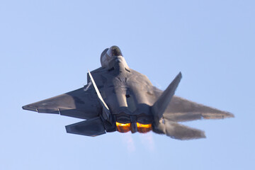 Close view of a F-22 Raptor in beautiful light ,  with afterburners on