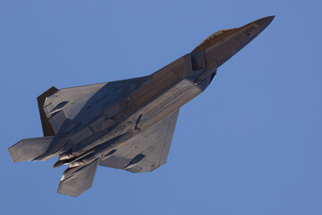 Fototapeta na wymiar Close bottom view of a F-22 Raptor in beautiful light