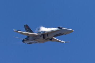 Very close frontal view of a F-18 Hornet in a high G maneuver, with condensation streaks around the  cockpit