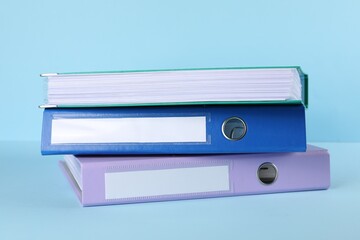 Stack of office folders on light blue background