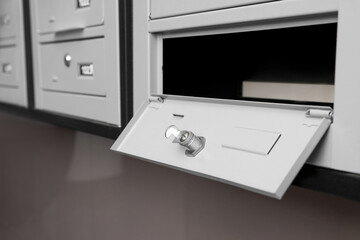 Open empty metal mailbox with keyhole indoors