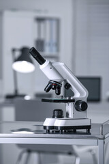 Modern medical microscope on metal table in laboratory