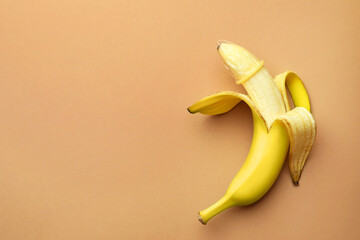 Banana with condom on pale orange background, top view and space for text. Safe sex concept