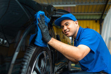 Man worker washing car service with micro fiber. Car wash cleaning wipe station. Employees clean a vehicle professionally detailing.