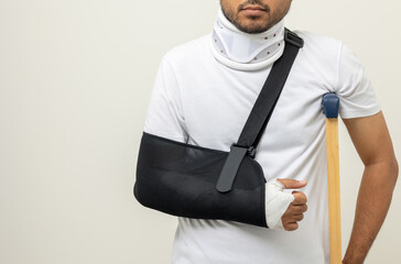 Young man broken arm and leg on isolated. Man put on plaster cast splint with walking sticks...