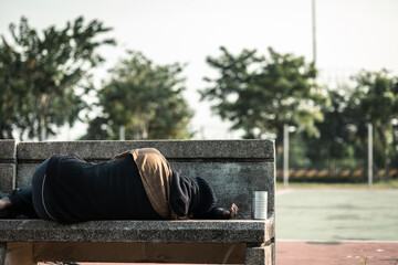 Poor tired stressed depressed hungry homeless man in the shadow city. Homeless man sitting on the street waiting for help food and money from people volunteer foundation donate.