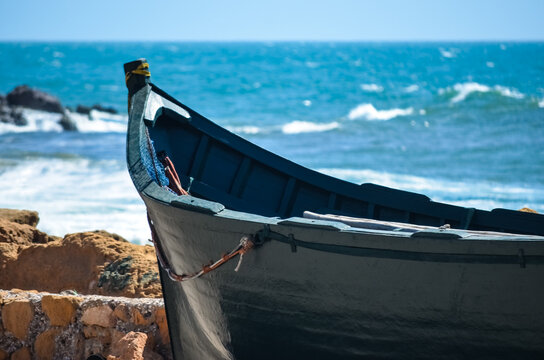 Wooden fishing boat in a quiet harbor near Mirleft Sidi Boulfdail, Morocco, with calm Atlantic waves, traditional boats, and peaceful historic maritime scenery.