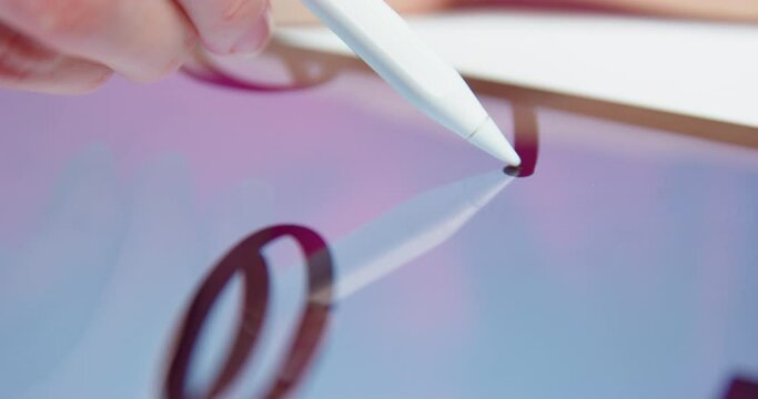 Hand holds a white pencil confidently draws a bold line on the tablet abstract drawing. Freelancer graphic artist illustrator drawing black image. Creating close-up digital paintings