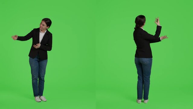 Corporate employee in suit doing advertisement over full body green screen background, showing ad or icon in studio. Office worker indicating presentation example standing on greenscreen background.