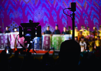 Movie camera in shadow, blurred background, show stage