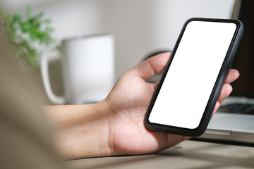 Close up view of woman using mobile phone at her office desk. Blank screen for your advertise design.