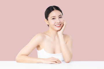 Studio shot Beautiful young Asian woman with clean fresh skin isolated on pink background.