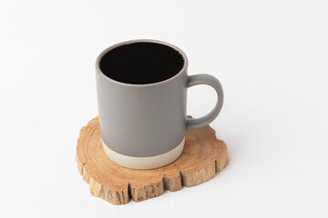 Hot black espresso coffee in brown ceramic cup (mug) on wood saucer plate isolated in white background.