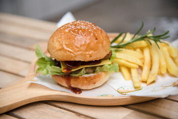 delicious homemade burgers of beef, cheese and vegetables on an old wooden table. Fat unhealthy food close-up