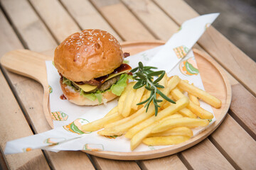 delicious homemade burgers of beef, cheese and vegetables on an old wooden table. Fat unhealthy food close-up