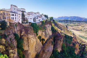 Fototapeta na wymiar Stunning mountainous landscape with houses hanging on the precipice in Ronda, Malaga Spain.