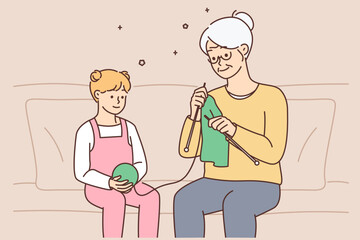 Little girl child knitting together with grandmother 