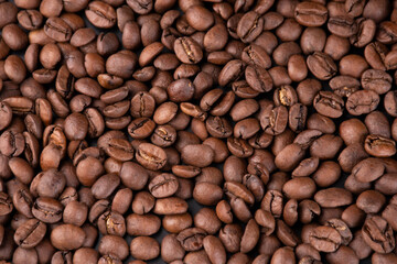 portion background of organic coffee beans direct from the Brazilian producer arabica type spilled and scattered texture in top view - obrazy, fototapety, plakaty