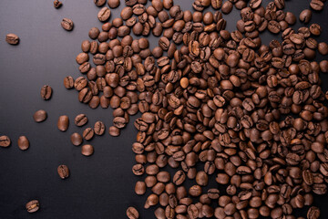 portion background of organic coffee beans direct from the Brazilian producer roasted arabica type spilled and scattered on black background gray gradient portrait texture - obrazy, fototapety, plakaty