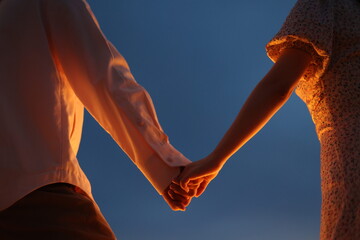 Couple holding hands under candlelight at sunset , Romantic