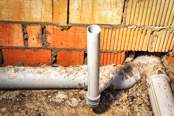 Sewer pipes in home basement. System of gray sanitary pipes when building a house. Sewer...