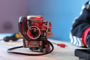 old carburetor from a four-stroke scooter on a table