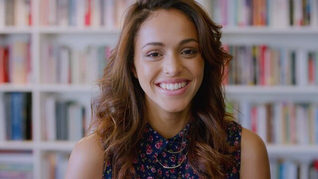 Woman, face portrait and smile in library or book store worker for knowledge, education or student studying. Happiness, mexican college girl and laughing for relax working in university with books