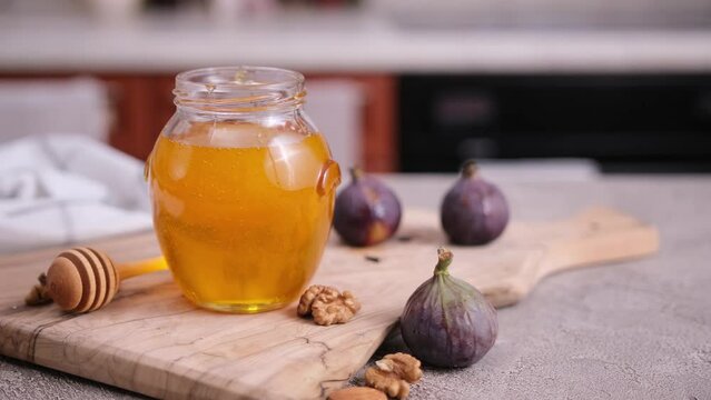 Honey in a glass jar or pot on kitchen table