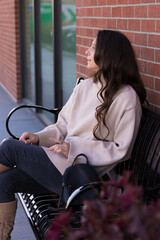 Young lonely woman sitting on a bench