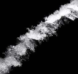 Obraz premium White snowflakes on a tree branch is isolated on a black background.