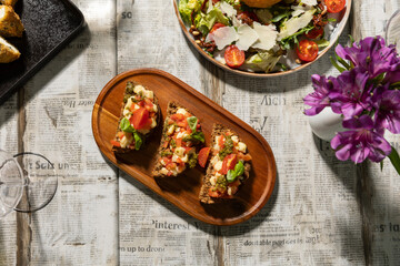 Bruschetta with cherry tomato and pesto served on a wooden board
