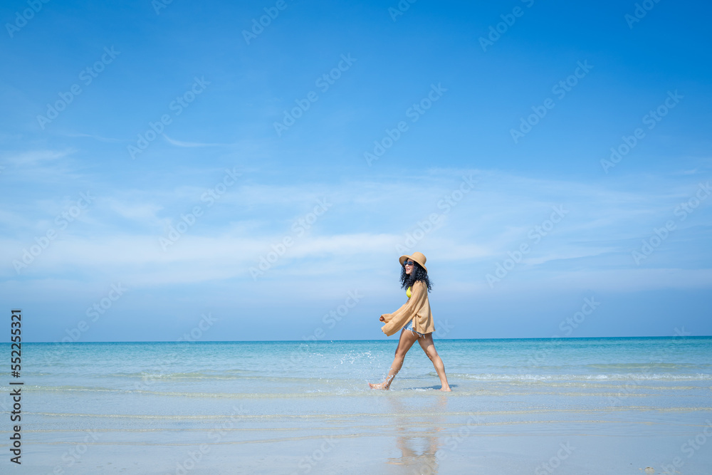 Wall mural Happy carefree woman enjoying beautiful sea on the beach,Summer holidays concept.