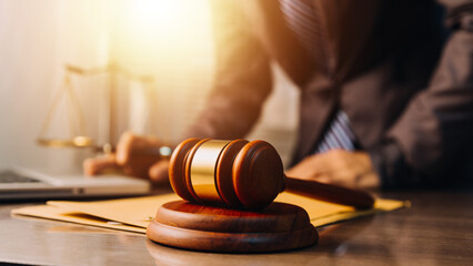 Obraz premium Business and lawyers discussing contract papers with brass scale on desk in office. Law, legal services, advice, justice and law concept picture with film grain effect