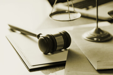 Justice and law concept.Male judge in a courtroom with the gavel, working with, computer and docking keyboard, eyeglasses, on table in morning light