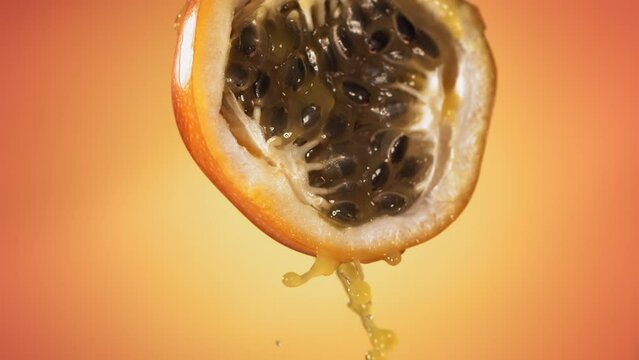 Slow Motion Macro Shot of Flowing Granadilla Juice from Halved Granadilla