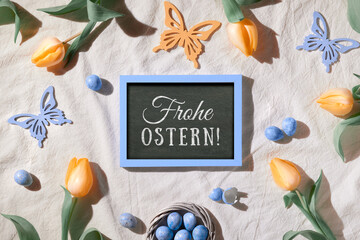Easter background. Decorated background with blackboard. Text Frohe Ostern means Happy Easter in...